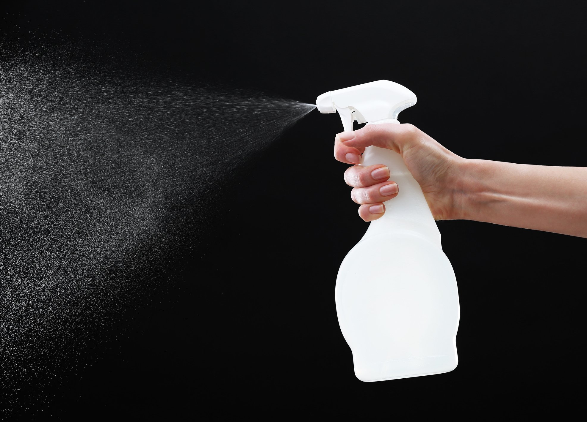 Hand Spraying Water on Black Background